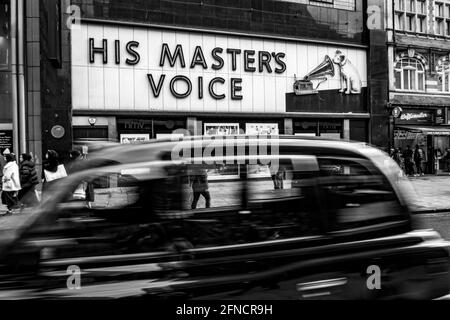 Black Cab passant par HMV dans Oxford Street avec célèbre Panneau chien et trompette Banque D'Images