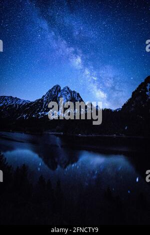 Encantats Twin Peaks vu de Estany de Sant Maurici lac dans une nuit de printemps avec la voie lactée sur la montagne (Aiguestortes, Catalogne, Espagne) Banque D'Images