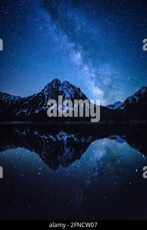 Encantats Twin Peaks vu de Estany de Sant Maurici lac dans une nuit de printemps avec la voie lactée sur la montagne (Aiguestortes, Catalogne, Espagne) Banque D'Images