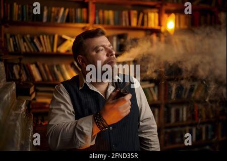 Un homme barbu fume un cigare au bureau Banque D'Images