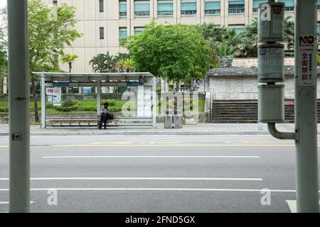 Taipei, Taïwan. 16 mai 2021. Une femme a vu s'asseoir à une station de bus vide à Taipei. Les gens restent chez eux après que le Centre central de commandement des épidémies ait fait passer le niveau d'alerte aux épidémies pour les villes de Taipei et de New Taipei au niveau 3. Crédit : SOPA Images Limited/Alamy Live News Banque D'Images