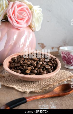 Grains de café dans un bol avec une tasse de café Banque D'Images