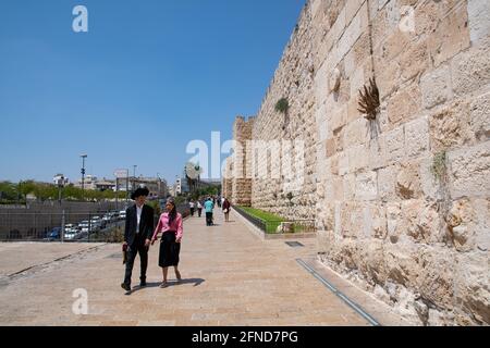 Un jeune couple juif marchant à proximité des remparts de la vieille ville de Jérusalem près de la porte Jaffa. Banque D'Images