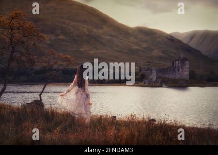 Asian Girl en face du château de Kilchurn en Écosse, post-traité en utilisant le bracketing d'exposition Banque D'Images