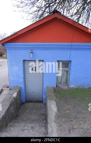 Une vieille petite maison bleue avec un toit rouge dans la ville. Jeu de couleurs. Banque D'Images