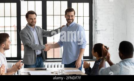 Fier patron encourageant et remerciant un employé heureux pour son bon travail Banque D'Images