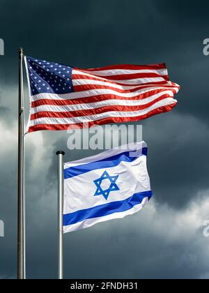 Les drapeaux des États-Unis et d'Israël flottent devant un ciel sombre et orageux, image symbolique de partenariat entre Israël et les États-Unis en des temps difficiles Banque D'Images