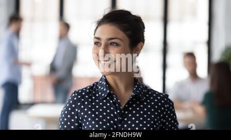 Portrait d'une femme d'affaires indienne heureuse et confiante souriant, regardant loin Banque D'Images