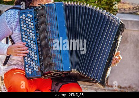 Femme jouant à l'extérieur accordéon - foyer sélectif et un peu de mouvement Flou sur les mains - coloré et rogné Banque D'Images