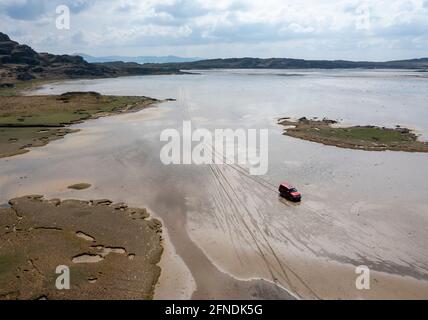 Un véhicule traversant le Strand à marée basse d'Oransay à Colonsay, Inner Hebrides, Argyll & Bute, Écosse, Royaume-Uni. Banque D'Images