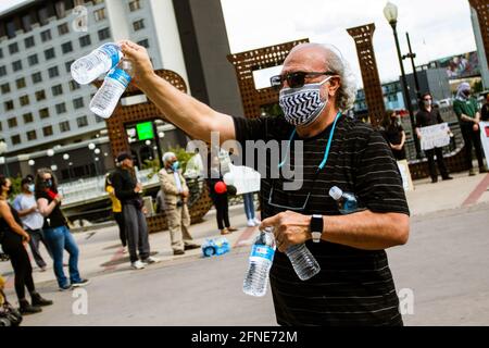 Reno, États-Unis. 16 mai 2021. Un homme remet des bouteilles d'eau pour protester contre les participants. Les manifestants pro-palestiniens se sont rassemblés pour un rassemblement sur la place de la ville pour partager leur soutien à la Palestine et leur colère face à ce qu'ils considèrent comme une agression israélienne. Les intervenants de l'événement ont exprimé leur désir pour les États-Unis de cesser d'envoyer l'aide militaire Israël. Crédit : SOPA Images Limited/Alamy Live News Banque D'Images