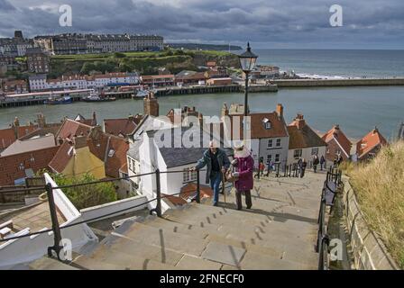 Les vacanciers marchent à quelques pas de la ville balnéaire jusqu'à l'abbaye de Whitby sur la falaise, la rivière Esk, l'estuaire d'Esk, Whitby, North Yorkshire, Angleterre, Royaume-Uni Banque D'Images