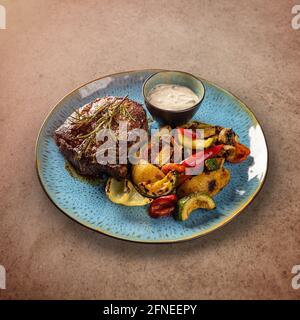 Steak de porc grillé et légumes grillés servis avec de l'ail sauce Banque D'Images