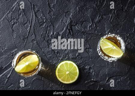 Tequila et limes, photo de haut sur fond sombre avec espace de copie Banque D'Images