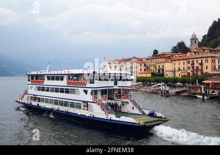 Vue sombre et brumeuse du matin sur le port et le village de Bellagio, petite ville sur le lac de Côme, en Italie, avec une eau calme et un ferry en bateau Banque D'Images