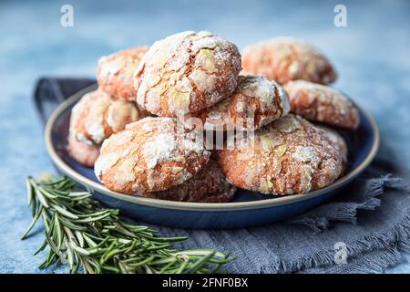 Petits gâteaux faits maison à l'orange et à la croûte de sucre en poudre, au romarin et aux oranges de sang siciliennes sur fond de béton bleu. Mise au point sélective. Banque D'Images