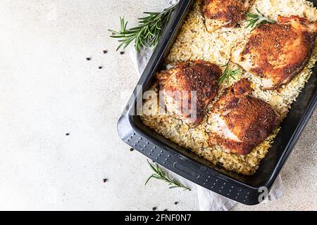 Viande de poulet cuite au four avec riz dans un plat de cuisson servi avec des légumes rôtis. Viande de poulet cuite au four avec riz. Vue de dessus. Mise au point sélective. Copier l'espace Banque D'Images