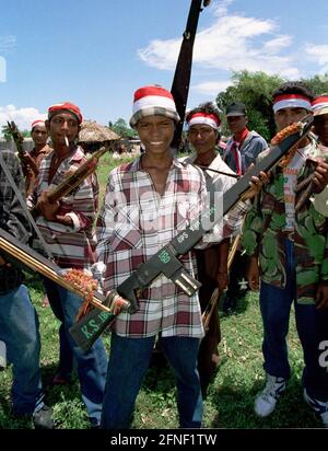 Des combattants Aitarak armés portant des bandeaux rouges et blancs lors d'un rassemblement de milices et d'unités paramilitaires pro-indonésiennes à Atabae, dans le district de Bobonaro. [traduction automatique] Banque D'Images