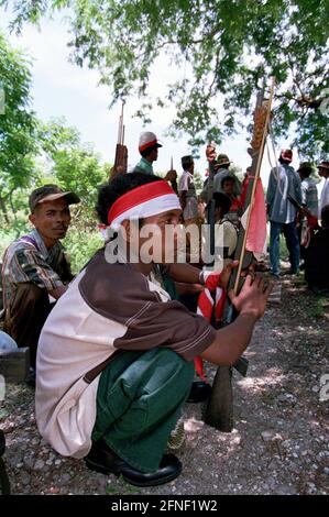 Des membres du Besih Merah Putih portant des bandeaux rouges et blancs lors d'un rassemblement de milices pro-indonésiennes et d'unités paramilitaires à Atabae, dans le district de Bobonaro. [traduction automatique] Banque D'Images