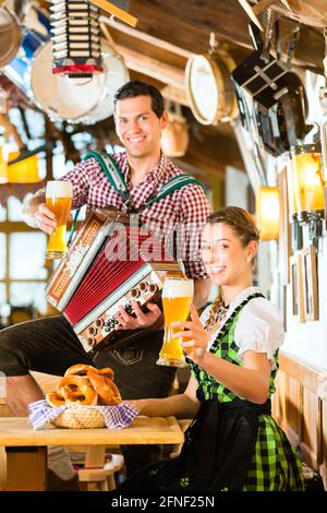 Le restaurant bavarois avec de la musique, les invités, les bretzels et bière de blé Banque D'Images