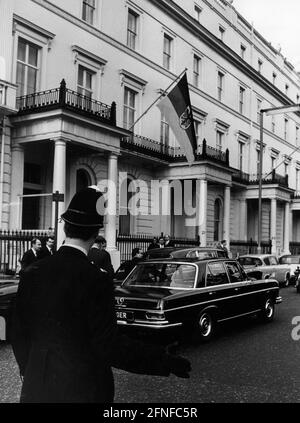 Devant la mission diplomatique allemande, il y a quelques voitures et un policier en uniforme. Le drapeau de la République fédérale d'Allemagne est suspendu au mur. Photographie non datée. [traduction automatique] Banque D'Images