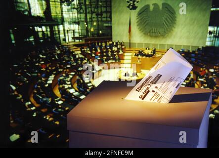 Symbolique pour les prochaines élections un bulletin de vote avec l'urne devant le fond de la salle plénière du Bundestag allemand. [traduction automatique] Banque D'Images