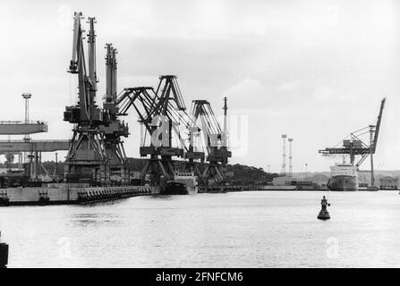 Dans le chantier naval de Rostock, vous pouvez voir les grues et en arrière-plan un navire qui est déchargé. Sur les bouées de canal montrent le chemin. Le port d'outre-mer de Rostock a été agrandi entre 1957 et 1960 et investi dans l'industrie des chantiers navals. [traduction automatique] Banque D'Images