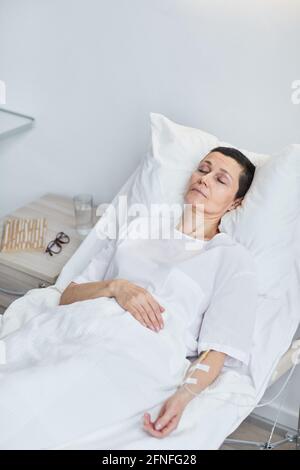 Femme malade et mature dormant à l'hôpital Banque D'Images