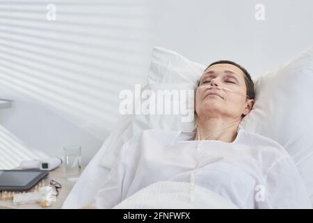 Femme sénichée au lit avec un compte-gouttes à l'hôpital quartier Banque D'Images