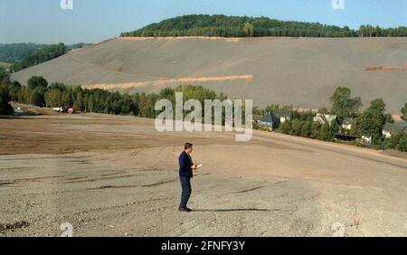 Saxe / GDR / Energie / 1992 décharges d'uranium à Schlema près d'Aue, mesure de la radioactivité. L'assainissement des principaux dommages environnementaux a commencé. La décharge est aplatie et des terrasses sont créées, des buissons sont plantés. L'accès de la population ne sera pas possible pour une très longue période. La restauration est effectuée par WISMUT AG. Une pelle hydraulique répand un mélange de terre végétale et de cendres. // Erzgebirge / Environnement / Atom / uranium / Mines la société commune germano-soviétique a été fondée après la formation de la RDA afin de donner à l'Union soviétique un accès continu à l'uranium dans le Banque D'Images