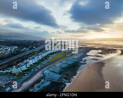 Coucher de soleil sur la promenade victorienne sur le front de mer à Llanfairfechan. Image aérienne avec l'autoroute A55 entre la promenade et la ville. Banque D'Images