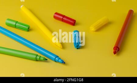 Stylos-feutres multicolores isolés sur fond jaune Banque D'Images