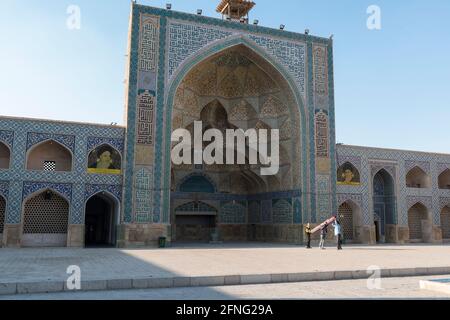 Trois hommes portant un tapis roulé devant l'iwan ouest de la mosquée du vendredi , Isfahan, Iran Banque D'Images