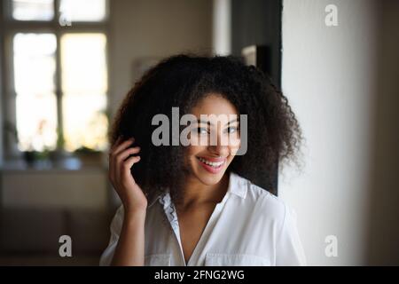 Portrait en gros plan d'une jeune femme à l'intérieur, regardant l'appareil photo. Banque D'Images