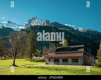 Belle ancienne église alpine rustique et montagnes alpines enneigées. L'église est située dans le village alpin de kandersteg en Suisse. Banque D'Images