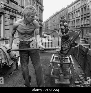 Saxe / lieux / pays GDR / Leipzig-Connewitz, 1990. Le quartier des travailleurs a été très décisé et devrait être démoli par parties selon les plans de la RDA. La photo montre une rue Gruenderzeit et le coalman. Il livre à la cave. Il était courant de faire une pelle sur les charbons dans la rue. Photo : le charbon est mis à la pelle dans le godet de la balance. Le seau est ensuite incliné et les charbons glissent dans un sac. // lignite / Energie / charbon / travail / kW / Etats fédéraux / [traduction automatique] Banque D'Images