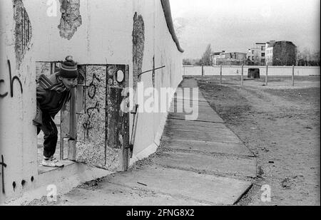 GDR, Berlin, 26.02.1990, mur de Potsdamer Platz, enfant regardant par une porte ..., (Weinhaus Hut), [traduction automatique] Banque D'Images