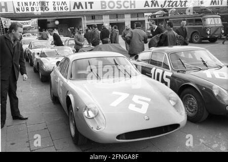 Course de 1000 km sur le Nürburgring 20.05.1964. Arrivée des voitures de course. Dans l'arrière droit un transporteur de voiture de Ferrari [traduction automatique] Banque D'Images