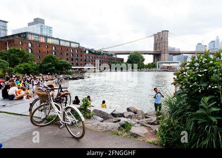 New York City, Etats-Unis - 24 juin 2018 : les gens apprécient le front de mer de la région de DUMBO à Brooklyn. Vue sur le pont aginst Broklyn et Cityscape of NYC Banque D'Images