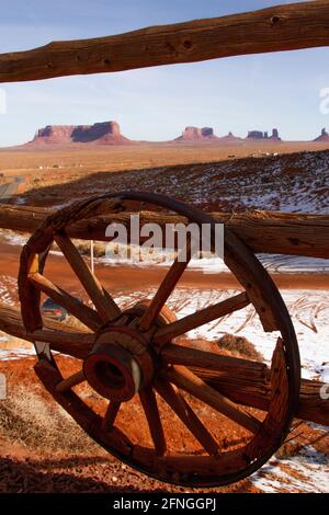 Monument Valley en hiver à travers une clôture en bois avec des roues de stagecoach de Gouldings Lodge, Arizona Banque D'Images