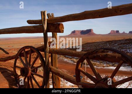 Monument Valley en hiver à travers une clôture en bois avec des roues de stagecoach de Gouldings Lodge, Arizona Banque D'Images