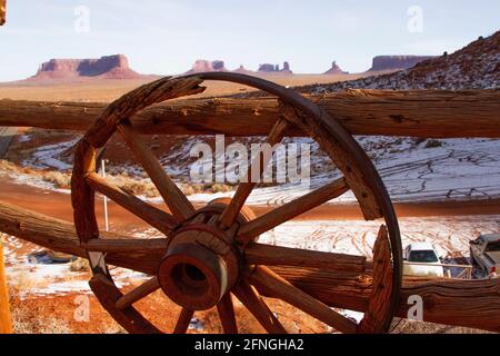 Monument Valley en hiver à travers une clôture en bois avec des roues de stagecoach de Gouldings Lodge, Arizona Banque D'Images