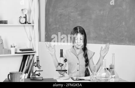 Petite fille avec microscope. Tubes d'essai de classe biologie pour filles. Leçon de science. Laboratoire scolaire. Expérience scientifique. Leçon fascinante. Explorer Banque D'Images