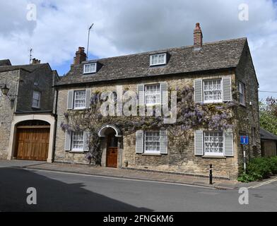 Glycine en fleur poussant sur le mur extérieur d'un Maison sur Park Street dans le nord de la ville d'Oxfordshire Woodstock Banque D'Images