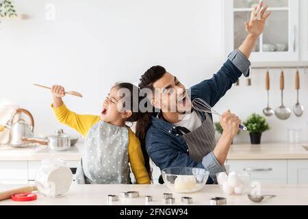 Joyeux père arabe et petite fille s'amuser tout en cuisant dans la cuisine Banque D'Images