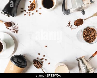 Cadre plat de pose de café, divers ustensiles pour faire du café et des tasses de café sur fond de marbre blanc. Concept du café. Vue de dessus. Copier l'espace Banque D'Images