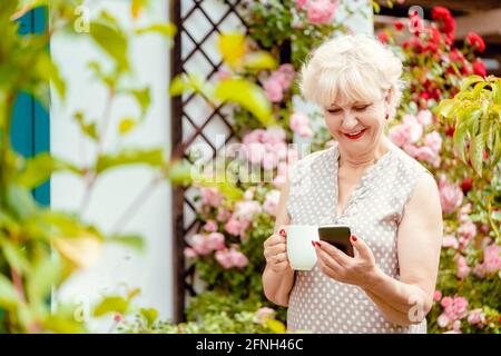 Une dame âgée ou une grand-mère utilisant le téléphone pour envoyer un message texte à sa famille Banque D'Images