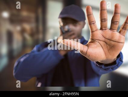 Composition d'un agent de sécurité mâle utilisant la main de main de talkie walkie sur un arrière-plan flou Banque D'Images