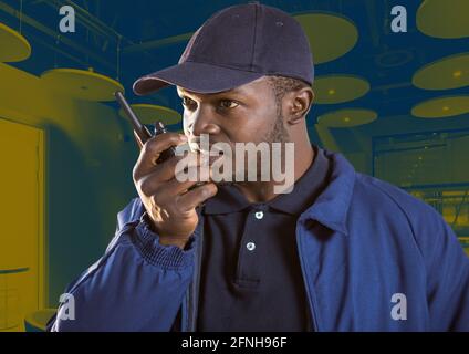 Composition d'un agent de sécurité masculin utilisant un talkie-walkie et un téléphone micro-casque sur l'arrière-plan du bureau Banque D'Images