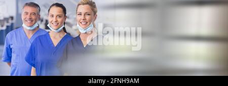 Composition des dentistes souriants de sexe masculin et féminin en chirurgie avec traînées de lumière floues Banque D'Images